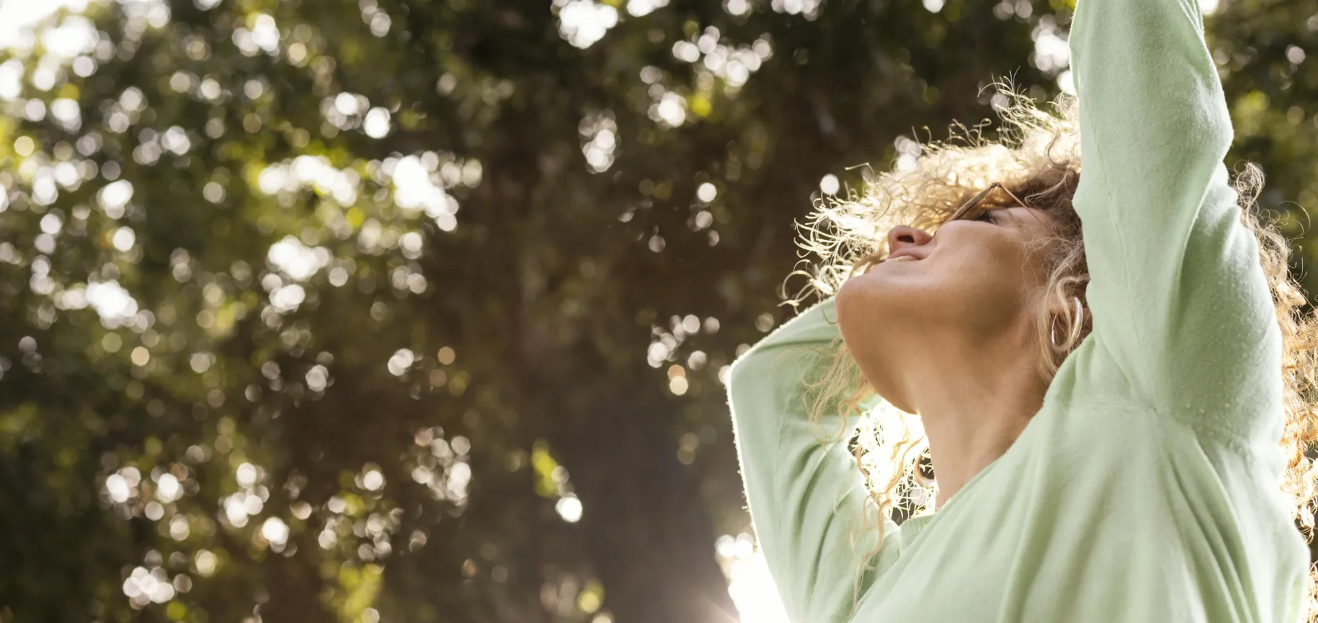 Mujer joven sonriente disfrutando de la naturaleza y bienestar natural