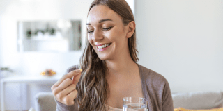mujer joven tomando vitaminas